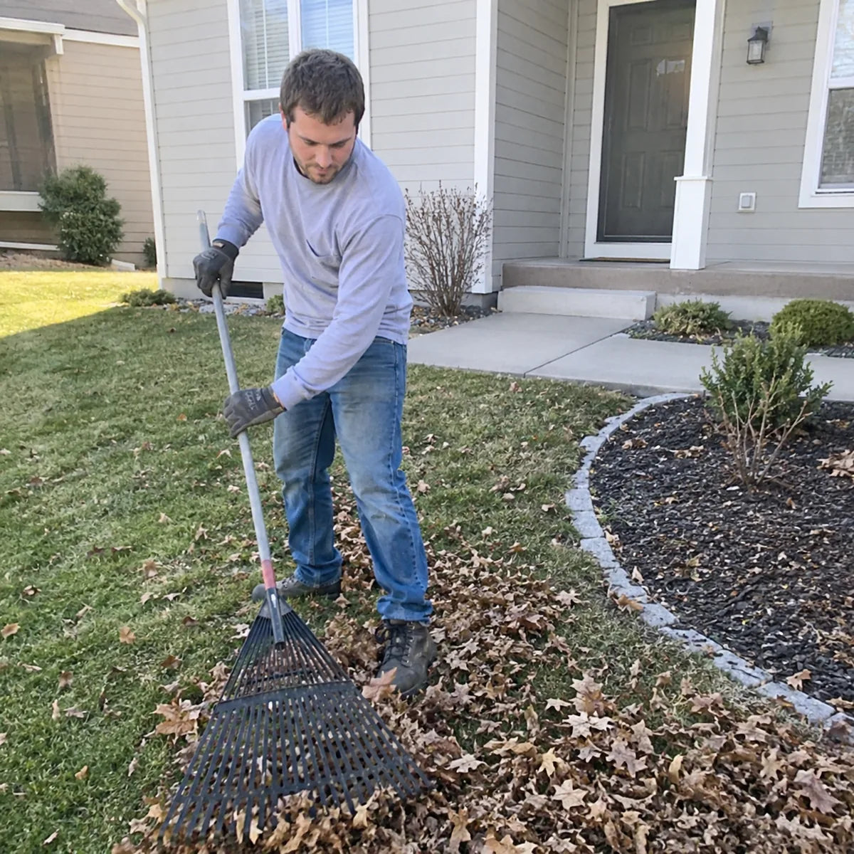 White male doing yard work in a suburban backyard